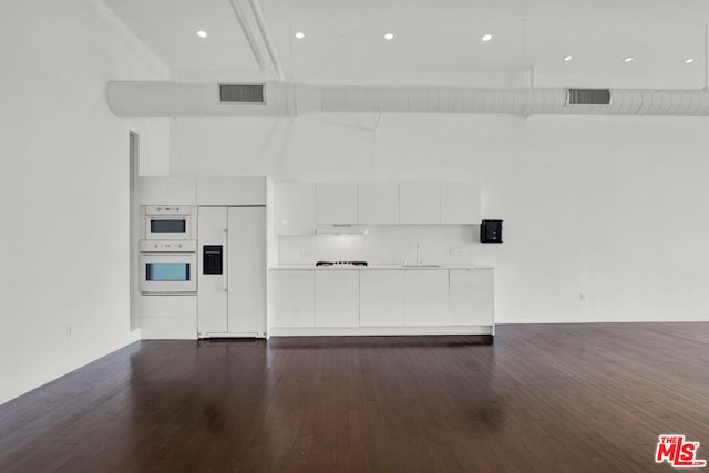 unfurnished living room featuring dark wood-type flooring and sink