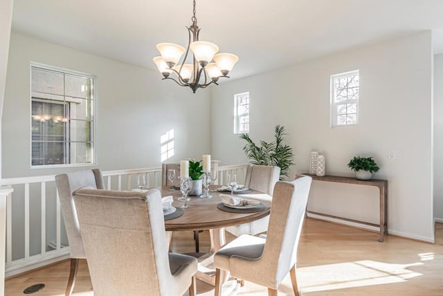 dining space with plenty of natural light, a chandelier, and light hardwood / wood-style floors