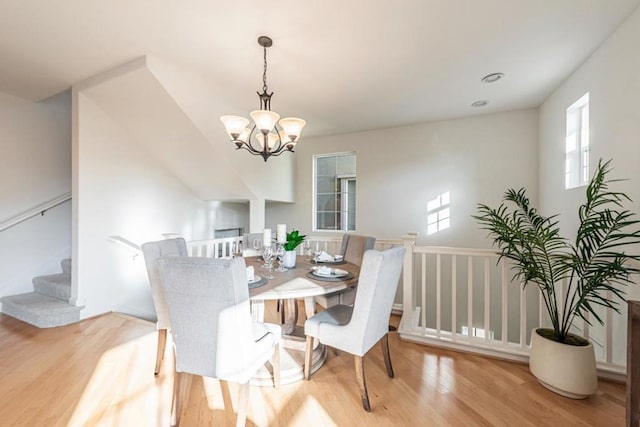 dining area with an inviting chandelier and light hardwood / wood-style flooring