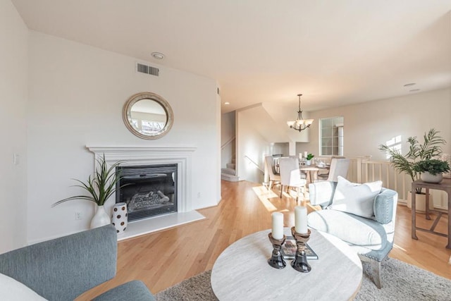 living room with a notable chandelier and light wood-type flooring