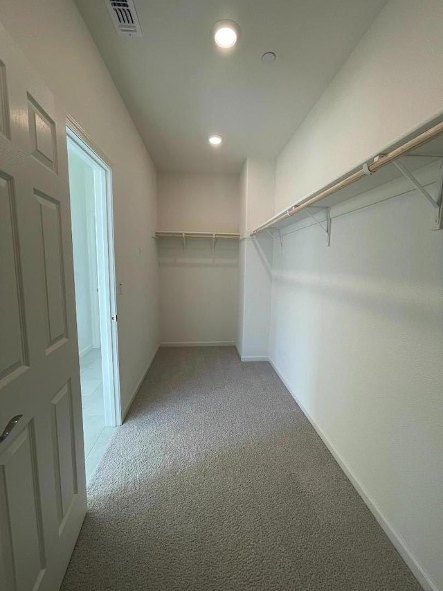 spacious closet featuring light carpet