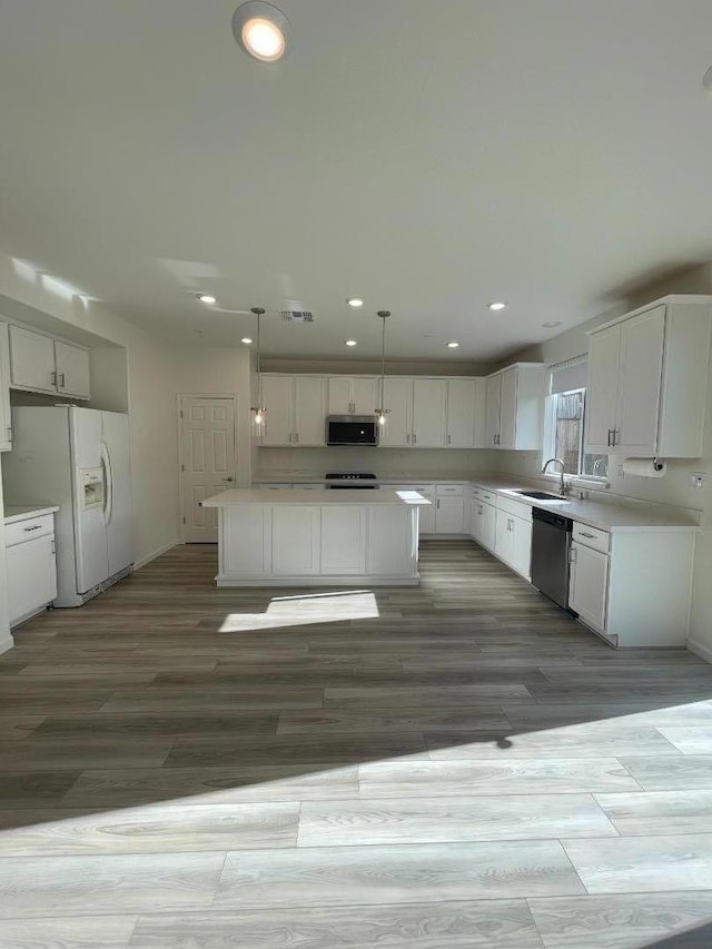 kitchen with white cabinets, a center island, stainless steel appliances, and pendant lighting