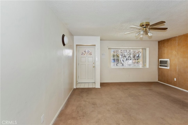 unfurnished room with ceiling fan, a textured ceiling, an AC wall unit, and light carpet