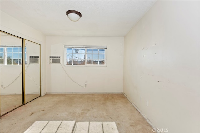 carpeted spare room with an AC wall unit