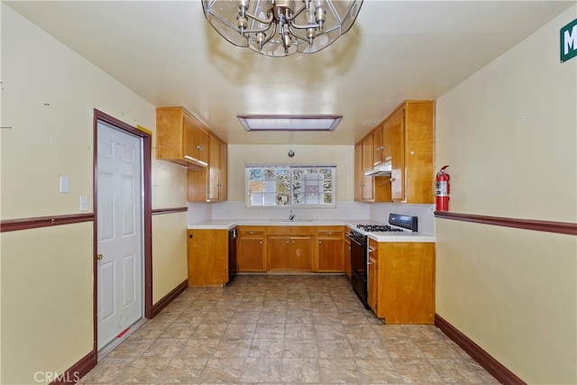 kitchen featuring decorative backsplash, sink, black appliances, and a notable chandelier