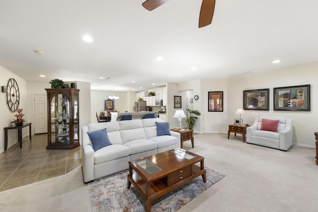 carpeted living room with ceiling fan with notable chandelier