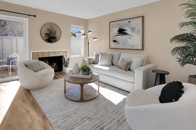 living room featuring hardwood / wood-style floors and a tiled fireplace