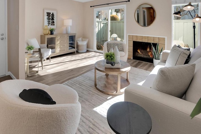 living room with light hardwood / wood-style floors and a tiled fireplace