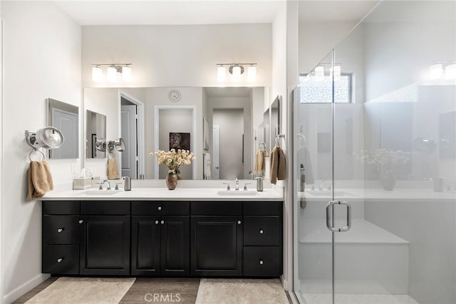 bathroom featuring hardwood / wood-style floors, a shower with door, and vanity