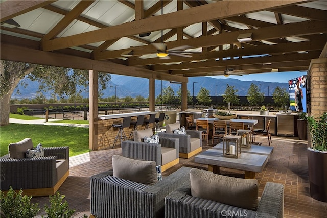 view of patio featuring a mountain view, an outdoor bar, an outdoor living space, and ceiling fan