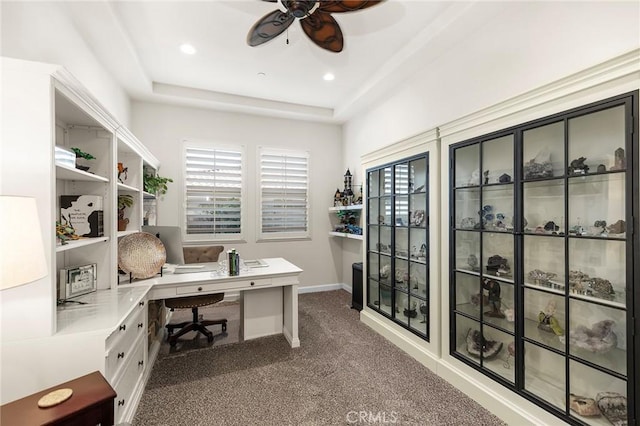 home office featuring ceiling fan, a tray ceiling, and carpet flooring