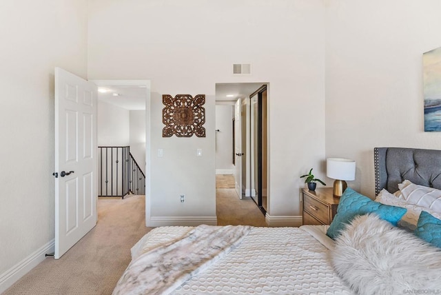 bedroom featuring light colored carpet and a high ceiling