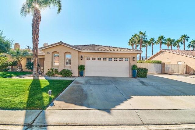 mediterranean / spanish-style home with a front yard and a garage