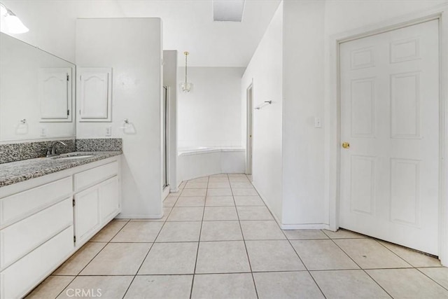 bathroom featuring a shower with shower door, vanity, and tile patterned flooring