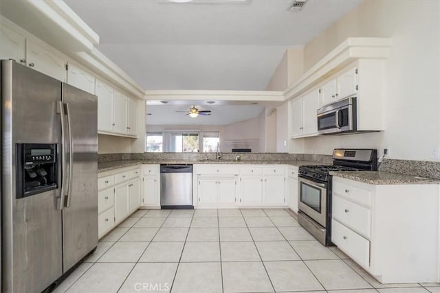 kitchen with ceiling fan, appliances with stainless steel finishes, white cabinetry, and lofted ceiling