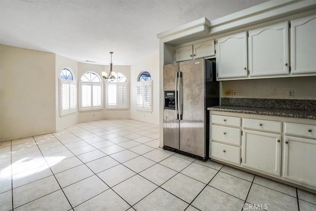 kitchen with decorative light fixtures, light tile patterned floors, stainless steel fridge, and a notable chandelier