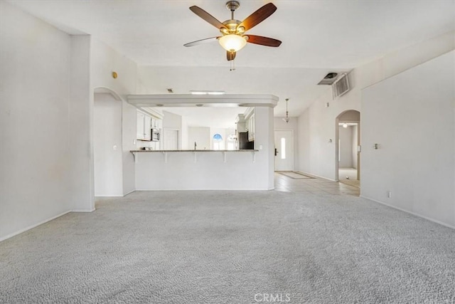 unfurnished living room with light carpet and ceiling fan