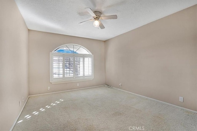 carpeted empty room featuring ceiling fan and a textured ceiling