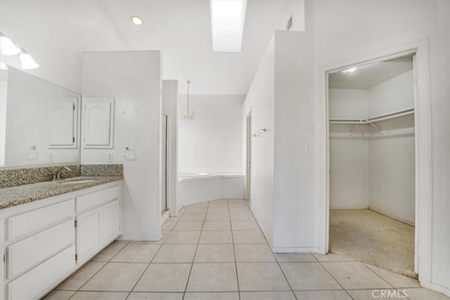 bathroom featuring tile patterned flooring, a tub, and vanity