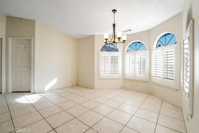 tiled empty room featuring a notable chandelier