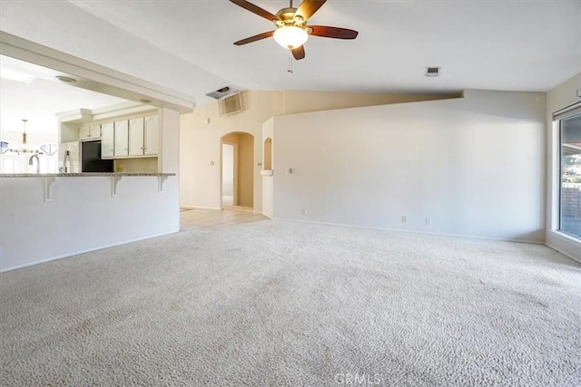 unfurnished living room featuring ceiling fan, light colored carpet, and lofted ceiling