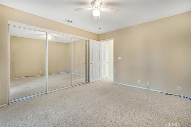 unfurnished bedroom featuring ceiling fan, a closet, and carpet floors