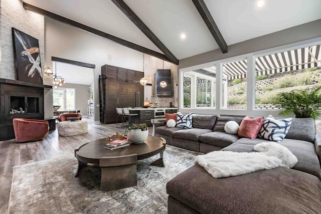 living room with beamed ceiling, a chandelier, high vaulted ceiling, and hardwood / wood-style floors