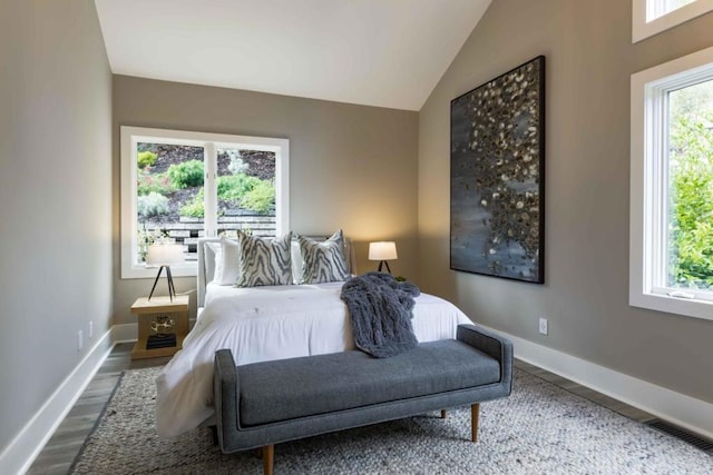 bedroom with wood-type flooring and vaulted ceiling