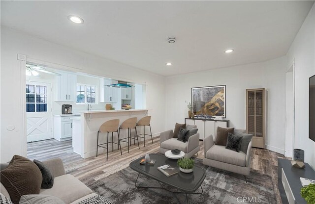 living room featuring light wood-type flooring and ceiling fan