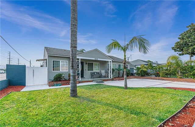 rear view of property featuring covered porch and a yard