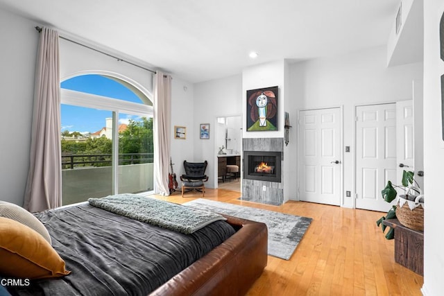 bedroom featuring a fireplace, recessed lighting, visible vents, wood finished floors, and access to outside