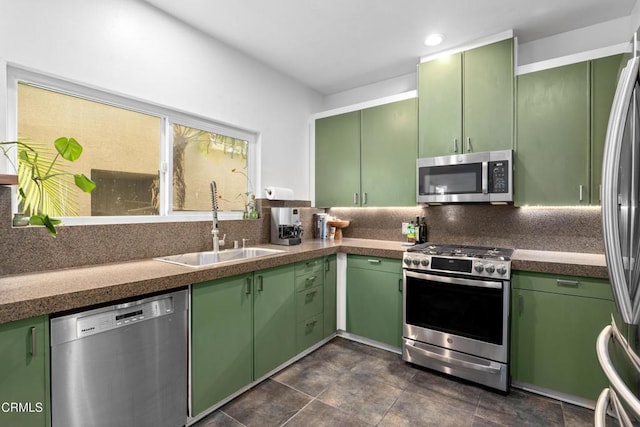 kitchen with green cabinets, appliances with stainless steel finishes, and a sink