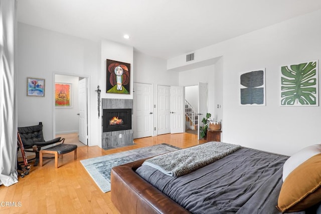 bedroom featuring a fireplace, visible vents, wood finished floors, and recessed lighting