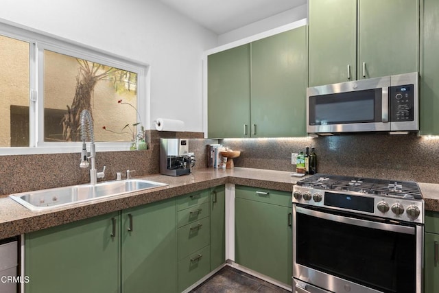 kitchen featuring green cabinetry, stainless steel appliances, and a sink