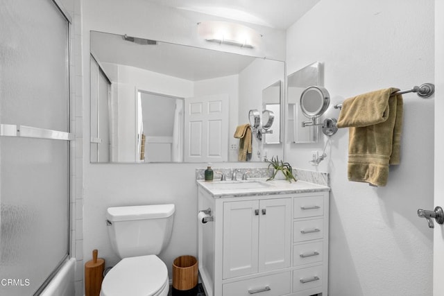 bathroom with combined bath / shower with glass door, vanity, and toilet