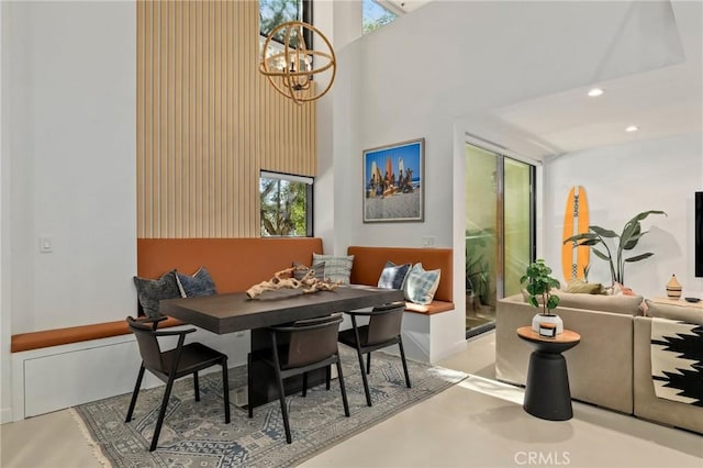 dining space with a high ceiling and a notable chandelier