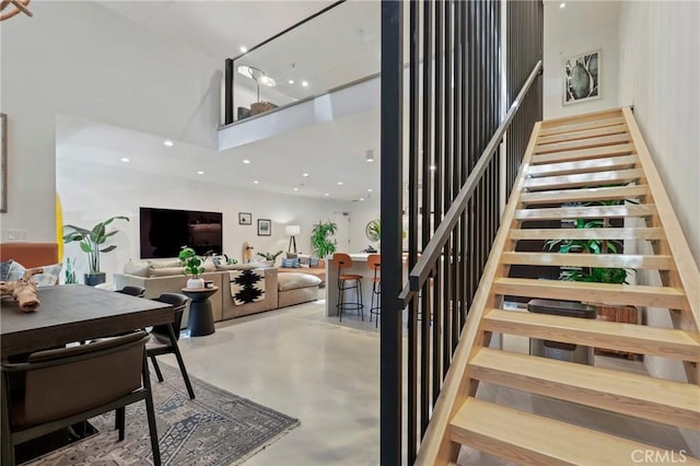 staircase with concrete floors and a high ceiling