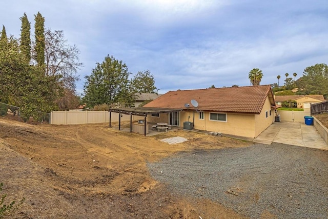 rear view of property with central air condition unit and a patio area