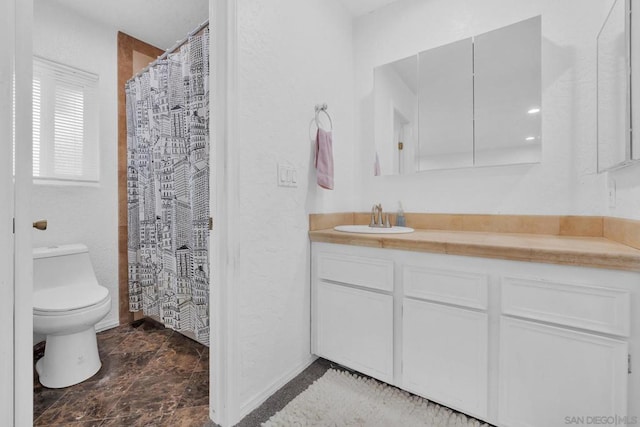 bathroom with toilet, walk in shower, and vanity