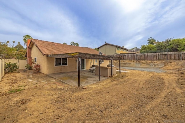 rear view of property with a hot tub and a patio