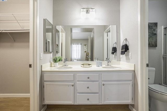 bathroom with toilet, vanity, walk in shower, and hardwood / wood-style flooring