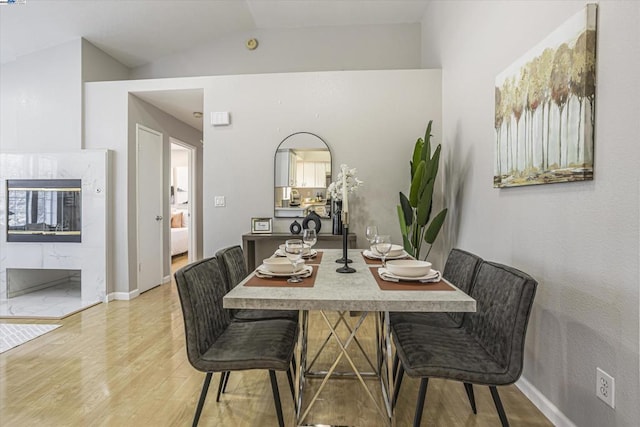 dining space with light hardwood / wood-style floors and lofted ceiling