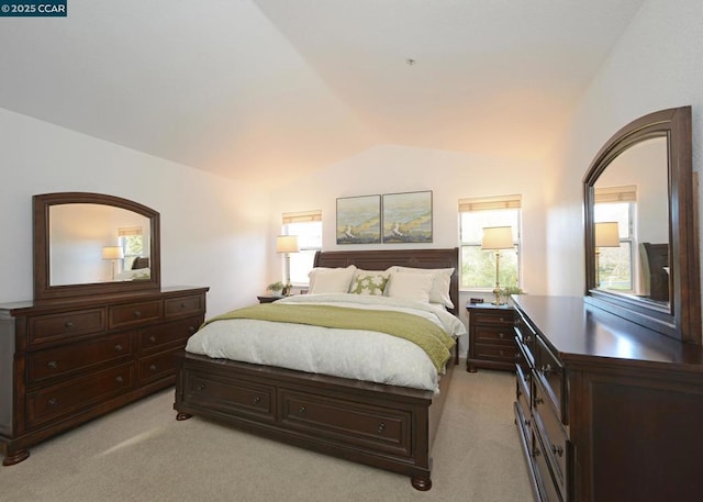 bedroom with light colored carpet and lofted ceiling