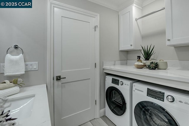 clothes washing area with separate washer and dryer, ornamental molding, and cabinets