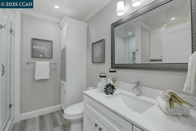 bathroom featuring vanity, toilet, walk in shower, hardwood / wood-style flooring, and crown molding