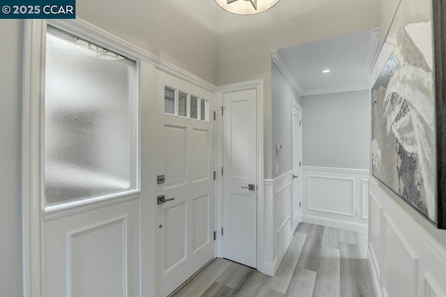 hallway featuring light wood-type flooring and crown molding