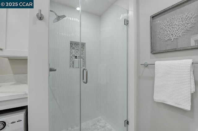 bathroom featuring walk in shower and washer / dryer