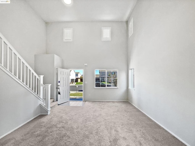 carpeted foyer entrance featuring a high ceiling