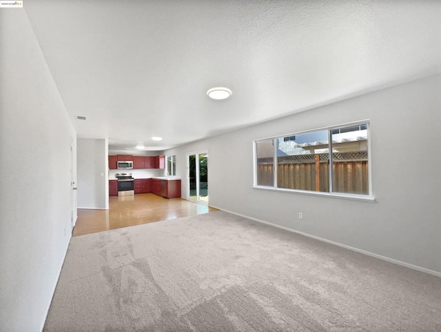 unfurnished living room featuring light carpet