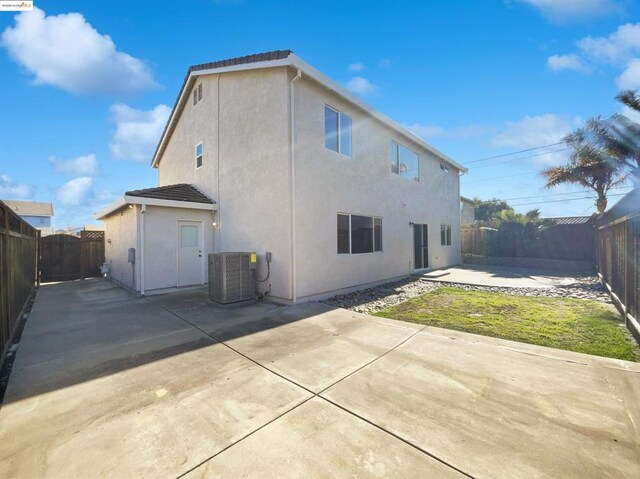 rear view of property featuring central AC and a patio area